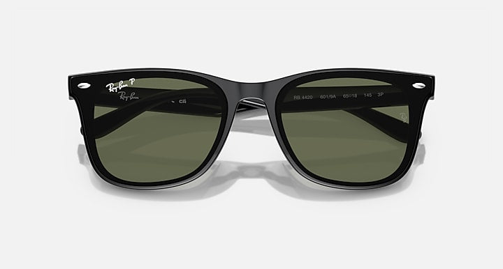 Black Ray-Ban sunglasses with green-tinted lenses and logo-marked temples