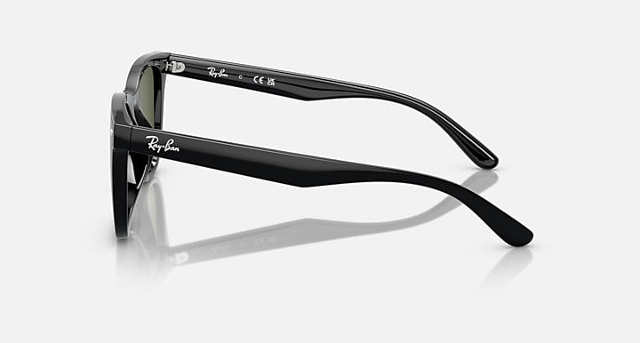 Black sunglasses side profile with green-tinted lenses and slim arms