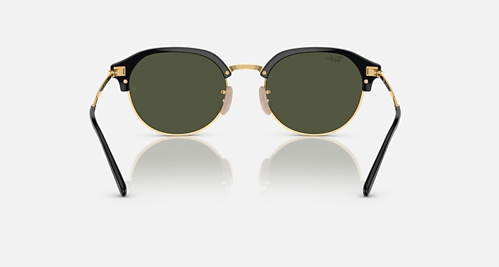 Round sunglasses with black frame, gold rim, and dark green tinted lenses