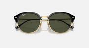 Front view of round sunglasses with black top frame, gold rim, and dark lenses