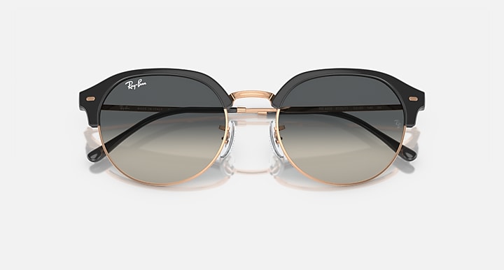 Round sunglasses with black frame and rose-gold rim, gray tinted lenses