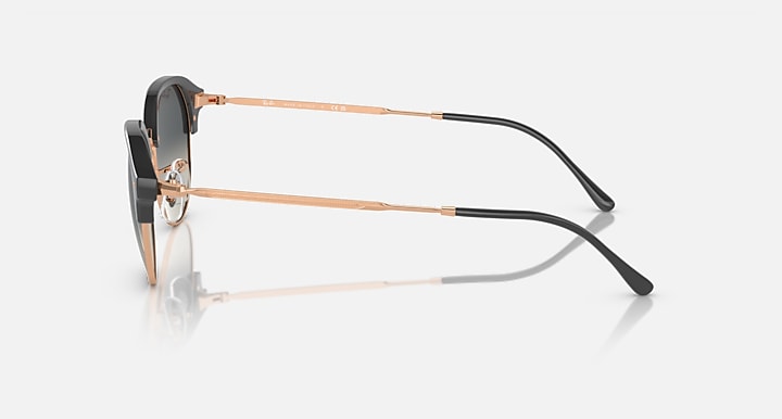 Side view of round sunglasses with black arms and copper-colored temples