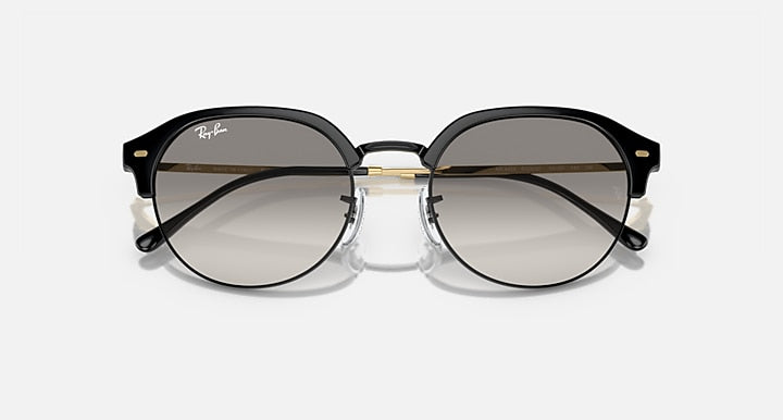 Round sunglasses with black frame and smoke-grey lenses, front view with gold hinges.
