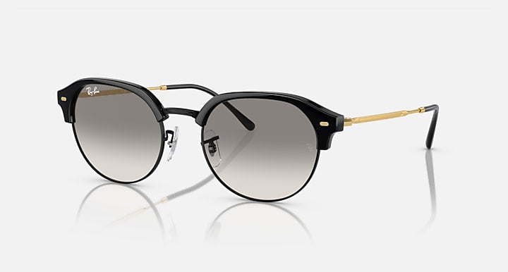 Round sunglasses with black frame, grey lenses, and gold metal arms.