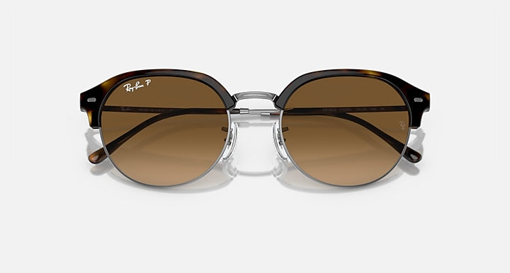 Round sunglasses with dark frame, brown lenses, and silver hinge bridge, front view.