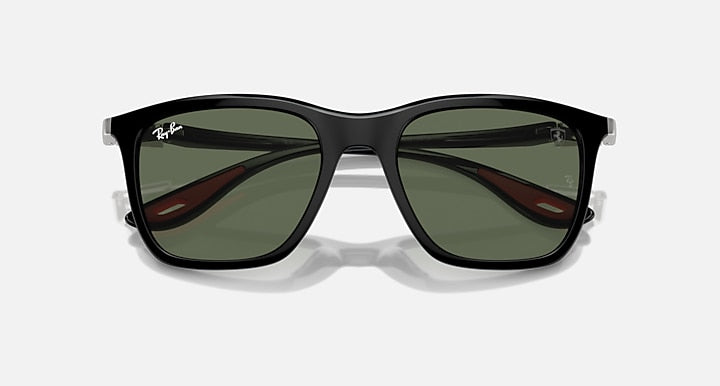 Black sunglasses with dark green lenses and red accents on the lens edges