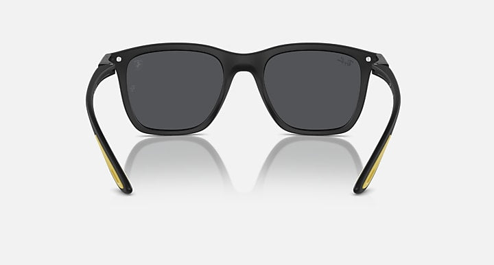 Matte black sunglasses with dark grey lenses and yellow-accented temple tips
