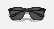 Matte black sunglasses with dark grey lenses and subtle yellow lens-edge details