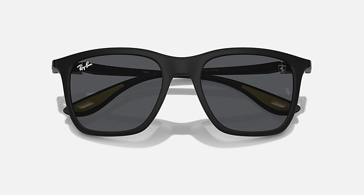 Matte black sunglasses with dark grey lenses and subtle yellow lens-edge details