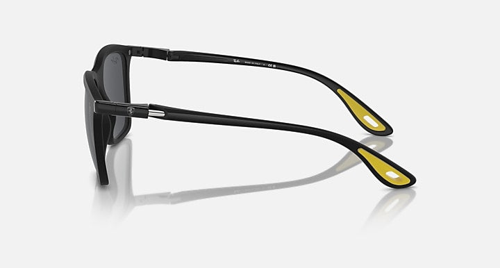 Matte black sunglasses side view with dark grey lenses and yellow temple accents
