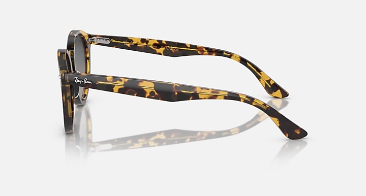 Tortoise round sunglasses side view with dark grey lenses and metal hinge arms