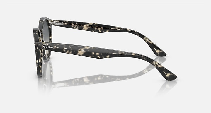 Black round sunglasses side view with dark grey lenses and patterned temple arms