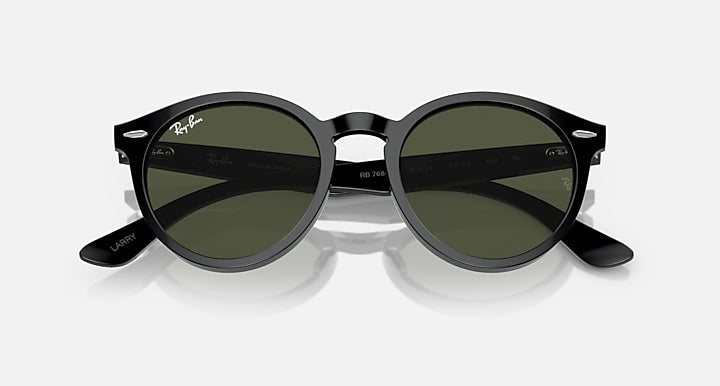 Ray-Ban round sunglasses with dark frames and green-tinted lenses, angled front