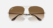 Ray-Ban aviator sunglasses with brown gradient tinted lenses and gold metal frame, front view