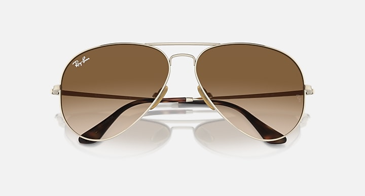 Ray-Ban aviator sunglasses with brown gradient tinted lenses and gold metal frame, front view