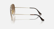 Ray-Ban aviator sunglasses with brown gradient tinted lenses and black temple tips, side view