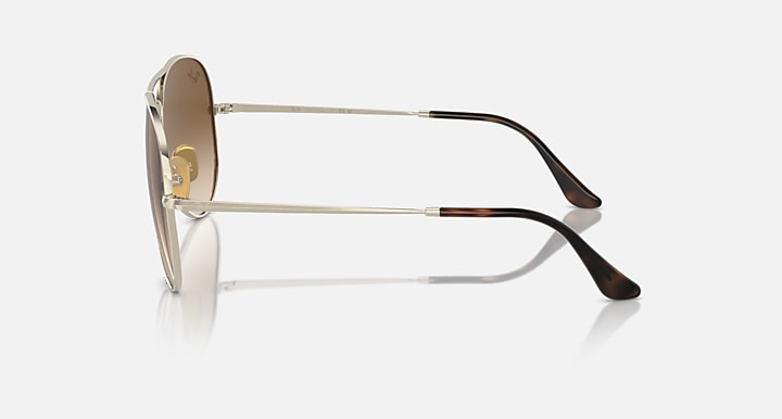 Ray-Ban aviator sunglasses with brown gradient tinted lenses and black temple tips, side view