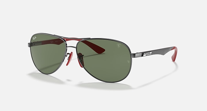 Ray-Ban aviator sunglasses, gunmetal frame with dark green lenses and red accents.