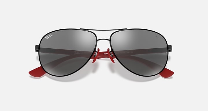 Ray-Ban aviator sunglasses, grey mirror lenses with black frame and red hinge detail.