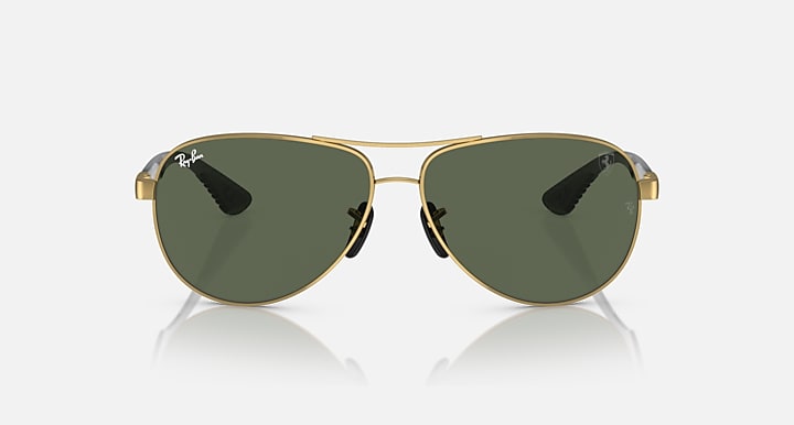 Gold-tone aviator sunglasses with dark green tinted lenses, wide teardrop shape