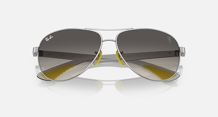 Silver-tone aviator sunglasses with dark gradient lenses and yellow bridge accents