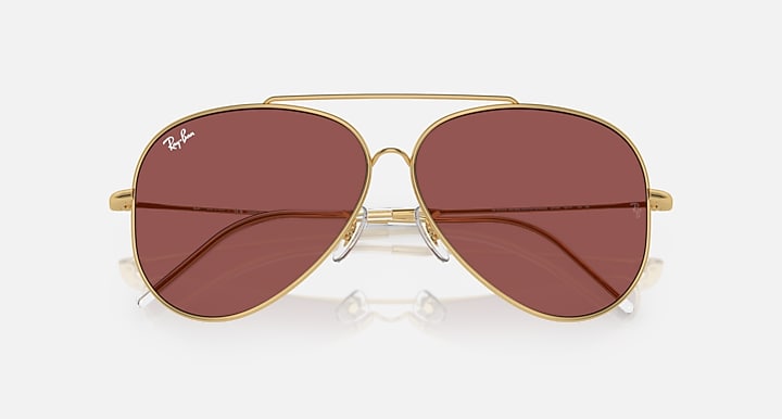 Ray-Ban aviator sunglasses, gold frame with maroon mirrored lenses and metal bridge.