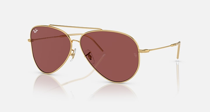 Ray-Ban aviator sunglasses with gold frame and maroon tinted lenses, teardrop shape.