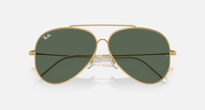 Ray-Ban aviator sunglasses with dark green lenses and gold frame, close front view.