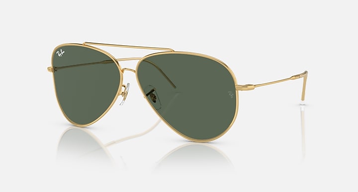 Ray-Ban aviator sunglasses with dark green lenses and gold frame, side view.