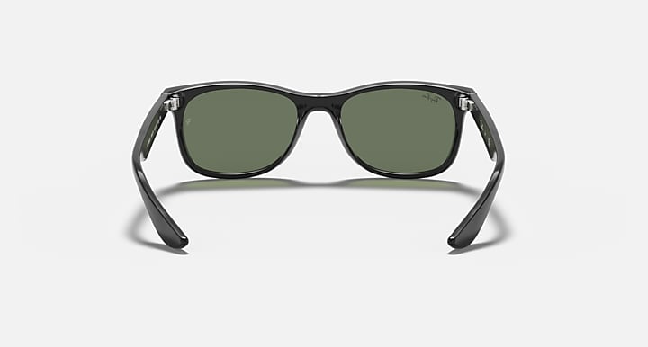 Black sunglasses with green lenses and visible metal hinges, front view