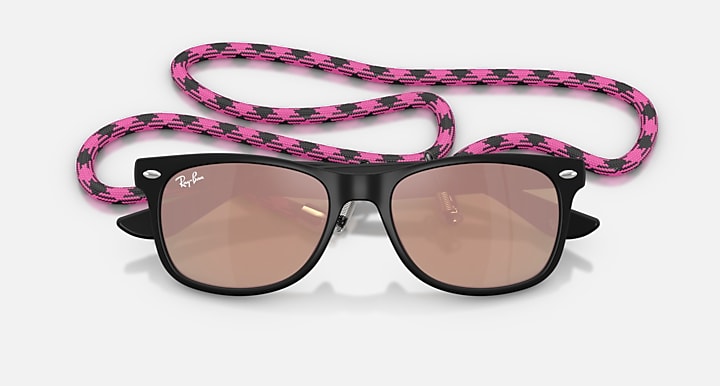 Ray-Ban Junior Wayfarer sunglasses, top view; black frame, pink patterned strap, brown lenses.