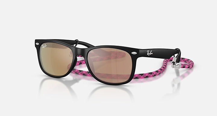 Ray-Ban Junior Wayfarer sunglasses with black frame, pink patterned temples, brown lenses.
