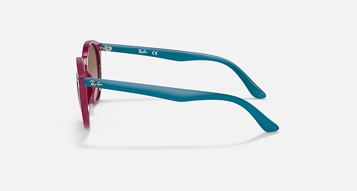 Teal round sunglasses with magenta temple tips, shown from the side.