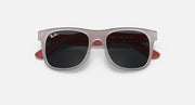 Sunglasses with light gray frames and dark lenses, with red side accents