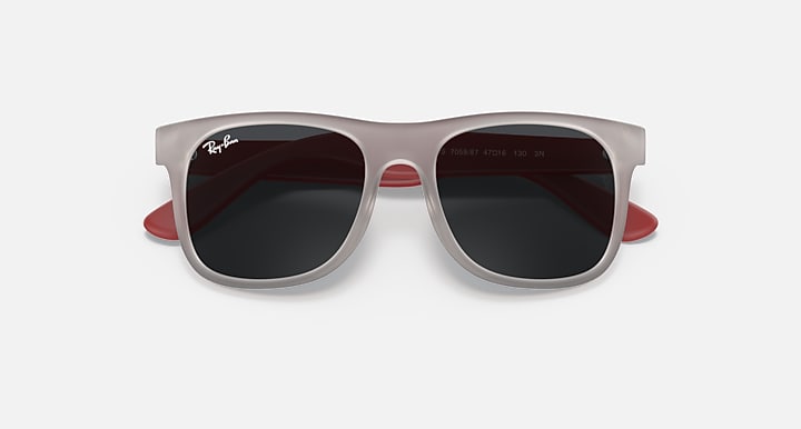 Sunglasses with light gray frames and dark lenses, with red side accents