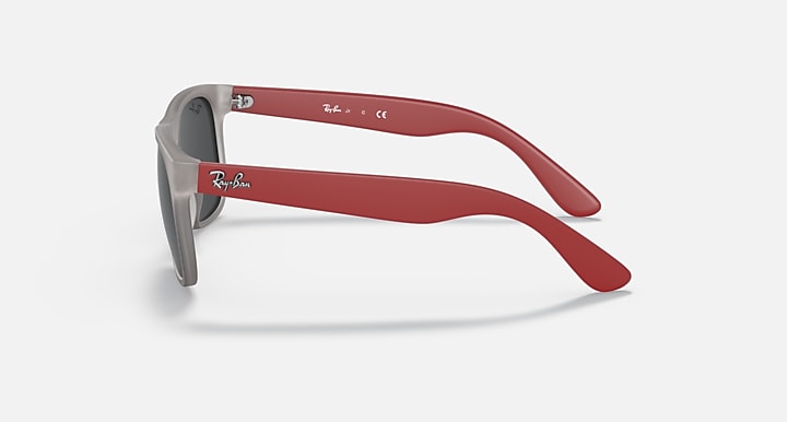 Sunglasses with gray frame and dark lenses, featuring red temples and side arms