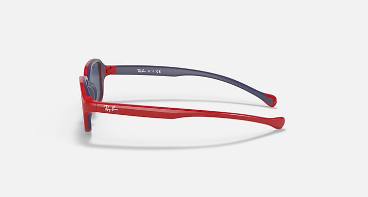 Red kids sunglasses side profile with dark blue lens and blue-tinted top rim