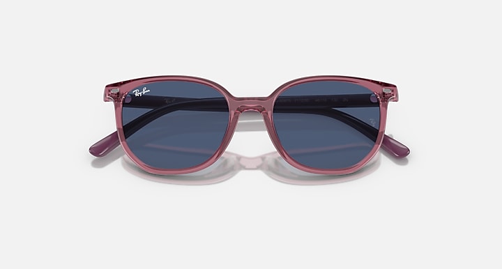 Ray-Ban Elliot RJ9097S sunglasses, angled top view, transparent pink frame with dark blue lenses
