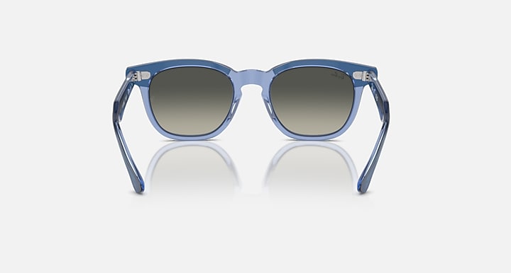 Ray-Ban RJ9098S sunglasses with light blue transparent frame and gradient brown lenses, front view