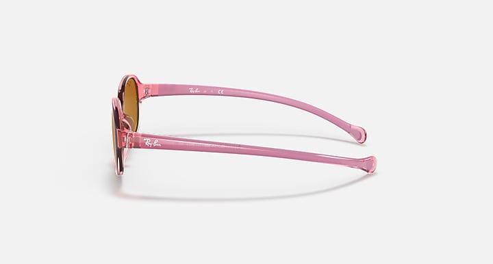 Pink oval sunglasses side view with brown tinted lenses and clear temples