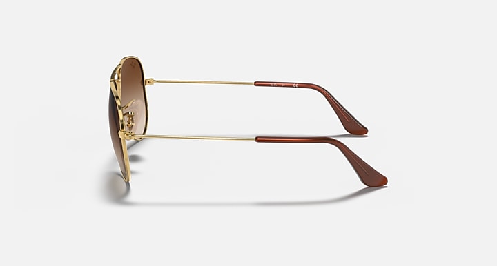 Ray-Ban aviator sunglasses with gold metal frame and brown gradient lenses, side view
