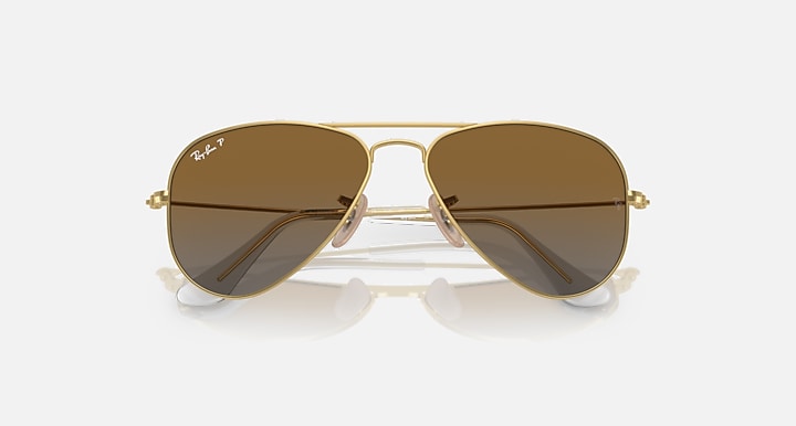 Ray-Ban aviator sunglasses with gold frame and dark brown gradient lenses, centered