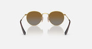 Round Ray-Ban sunglasses with gold frame and muted brown lenses