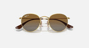 Round Ray-Ban sunglasses with gold frame and brown gradient lenses, curved temples