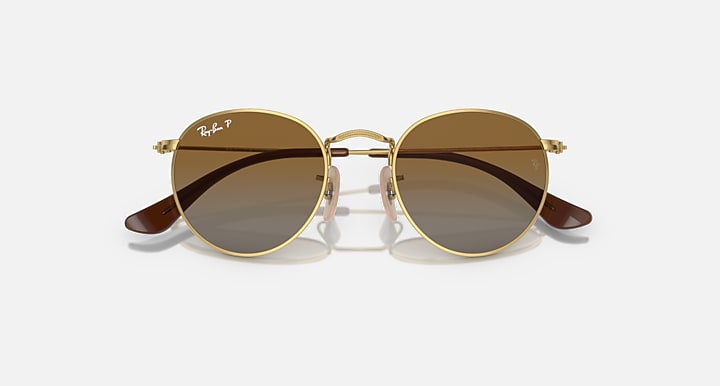 Round Ray-Ban sunglasses with gold frame and brown gradient lenses, curved temples
