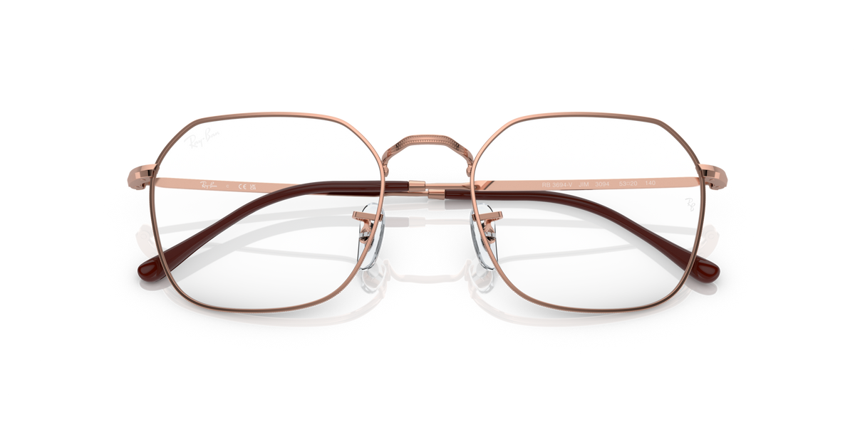 Oval prescription eyewear frames with clear lenses, light gold metal, dark accents