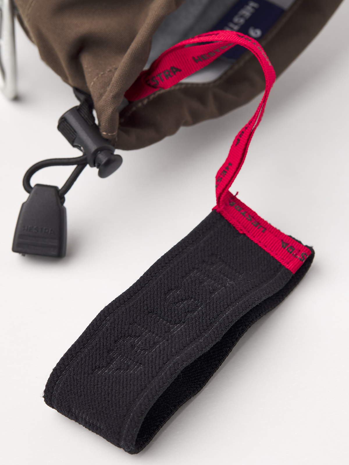 Black wrist strap with red lanyard and Hestra webbing label