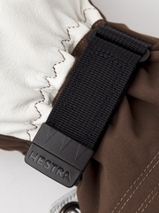 White ski mitten with black HESTRA-branded strap clip and woven texture