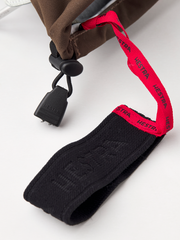 Dark brown Hestra ski mittens with black wrist strap and red logo elastic