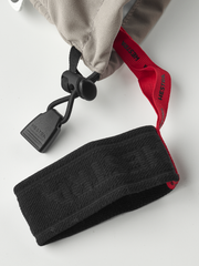 Light beige Hestra ski glove with red cuff text, drawcord loop, and fingerless? grip